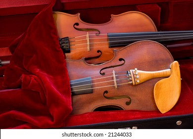 Two violins covered by cloth in a case