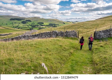Two walkers enjoying a hike between Settle and Feizer near Stackhouse in the Yorkshire Dales