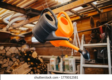 Two Watering Cans Inside A Garden Shed