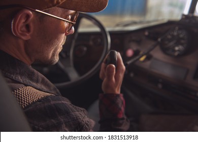 Two Way CB Radio Convoy Communication. Caucasian Trucker in His 40s Making Conversation Using Built In Truck Cabin Radio. Transportation and Communication Theme. - Powered by Shutterstock