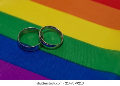 Two Wedding Rings On Lgtb Flag Background, Gay Marriage Concept