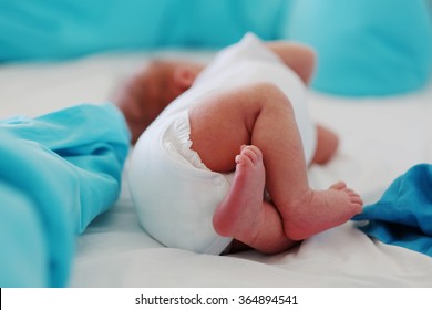 Two Weeks Old Newborn Baby's Legs And Bottom In Diaper