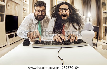 Two weird computer geeks having fun on computer