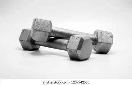 two well worn 5 pound silver dumbbells isolated on white