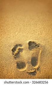 Two Well-shaped Human Footprints In The Sand