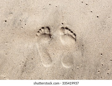 Two Well-shaped Human Footprints In The Sand