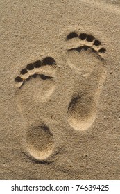 Two Well-shaped Human Footprints In The Sand