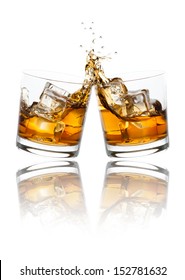 Two whiskey glasses clinking together, isolated on white.