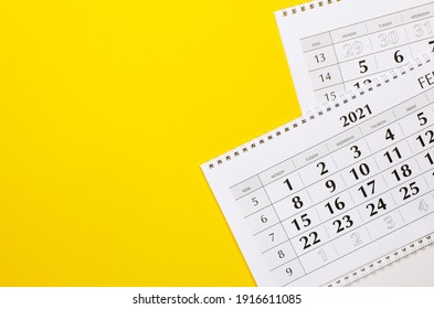 Two white blank 2021 calendars on solid yellow background with copy space, business meeting schedule, travel planning or project milestone and reminder concept.