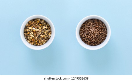 Two white bowls with Chamomile and Valerian root tea, on blue background.