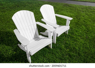 Two White Cape Cod Adirondack Chairs On The Green