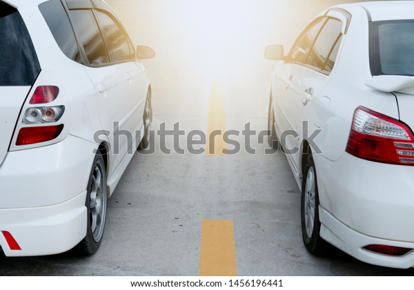 Two white car prepare to race on the road with
yellow line or trip to
travel.