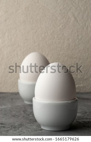 Two white chicken eggs in white egg cup