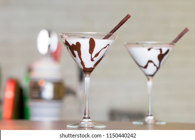 Two White Chocolate Martini Garnish With A Chocolate Stick On The Bar Desk