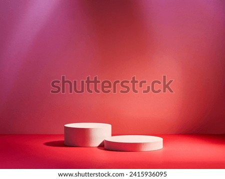 Two white circular plinths on pink and red stage with spotlight
