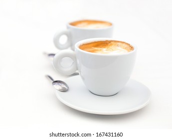 Two white cups of Cappuccino coffee with heart shaped milk foam - Powered by Shutterstock