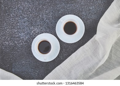 Two white cups of espresso on grey grunge background. Stylish toning, place for text. Flat lay. Top view. Copy space.