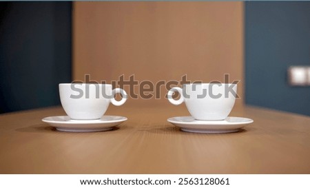 Two white cups on a kitchen countertop, ready for a warm drink. Concept: style, drinks, and interior, creating a cozy, modern atmosphere for enjoying beverages in everyday life.