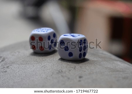 Two white dice on a table close up on blurry background