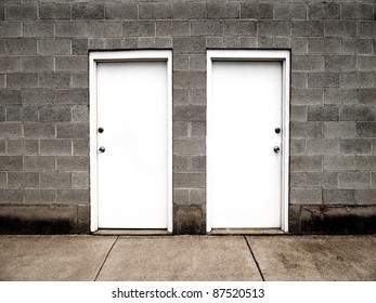 Two White Doors On Brick Wall Illustrating Choices