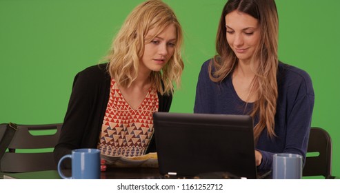 Two White Female Tourists With Map And Laptop At Cafe On Green Screen