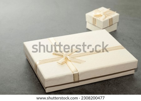 Two white gift boxes, small and large, for an old plaster table.