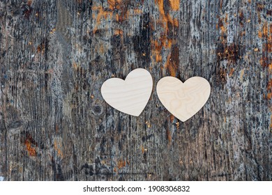 Two white hearts lie on a dark textured wooden surface, valentine's day