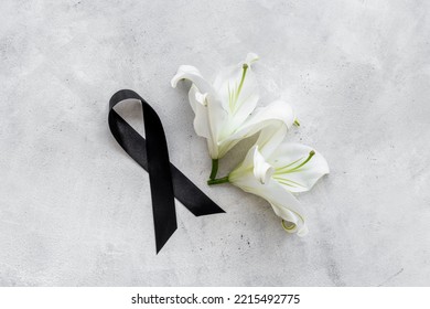Two white liles flowers with black ribbon. Mourning or funeral background
