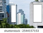 Two white mock up vertical large LED display billboard on tower building with blue sky background .clipping path for mockup