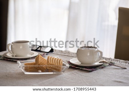 Two white oldfashioned cup of tea or caffee on the table at home. Stay at home concept.