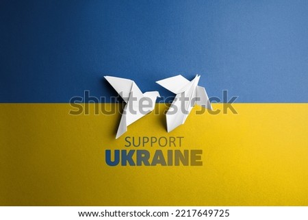 two white paper dove in the center on background with words support Ukraine, with blue yellow color. symbol of freedom
