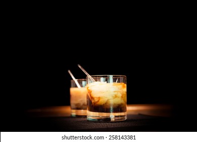 Two White Russian Cocktails On The Bar Stand On Rubber Mat. Shallow DOF And Marsala Tonned