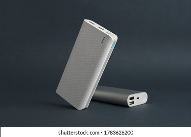 two white silver tilted power banks standing and sleeping on a simple black background minimal 