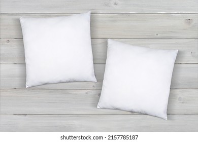 Two white throw pillows taking a nap on a modern gray wood background