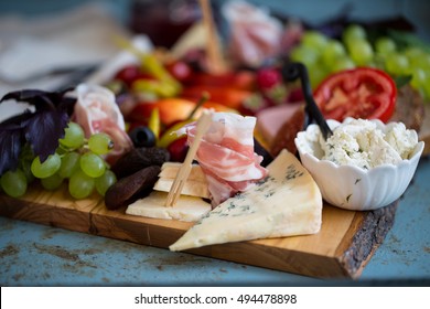 Two White Wine Glasses With Cheese Platter With Fruits And Meats