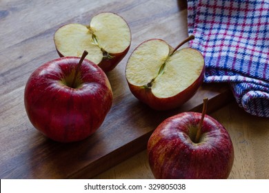 Two Whole And Two Halves Royal Gala English Apples With Cloth On Wooden Background. Cut Apple With Bruise Turning Brown, Oxidation. Copy-space, Close-up, Selective Focus, Back Lit, 