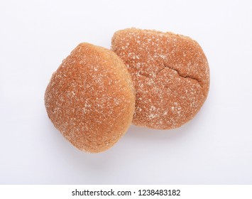 Two wholewheat breadcake baps on white background from above