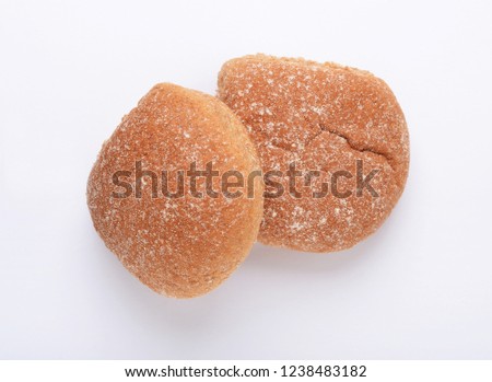 Two wholewheat breadcake baps on white background from above