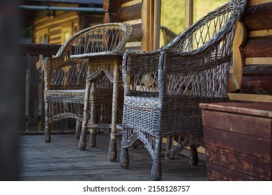Two wicker chairs and table on veranda, closeup shot. Wicker furniture in garden exterior