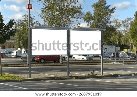 Two wide format posters in the parking lot.
