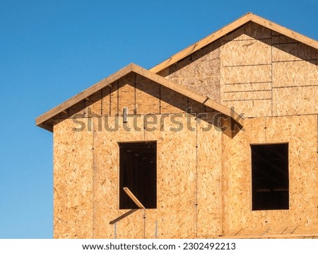 Two window openings on the upper story of a single-family suburban house under construction on a sunny morning in southwest Florida