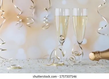 Two Wine Flutes Filled With Champagne With A Wedding Ring In One Of Them. Engagement Concept.