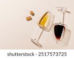 Two wine glasses alongside several corks, all arranged on a bright background. The hard light creates sharp shadows, adding a dramatic effect to the scene, emphasizing the shapes