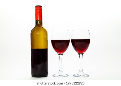 Two Wine Glasses Filled With Red Wine And An Half Empty Bottle