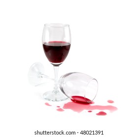 Two wine glasses. Spilled red wine. White background.