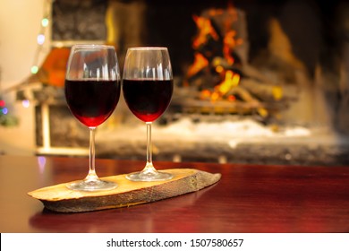 Two Wineglass Of Red Wine In Front Cozy And Warm Fireplace, In Country House. Winter Or Autumn (fall) Vacation. Happy New Year, Merry Christmas Or Saint Valentine's Day. Romantic Evening For Couple.