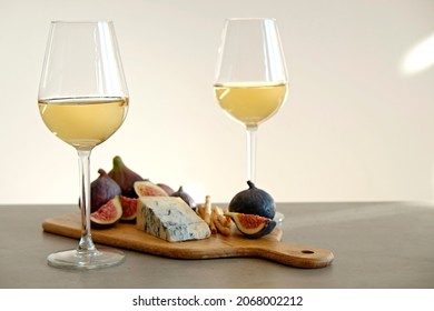 Two Wineglasses Of Vintage Chardonnay With Delicious Appetizers. Couple Of Glasses Of White Wine, Italian Breadsticks, Figs And Grapes. Interior Background. Close Up, Copy Space.