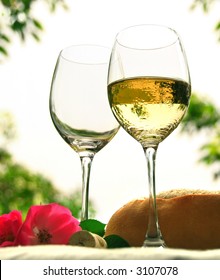 Two Wineglasses With White Wine On The Table Outside