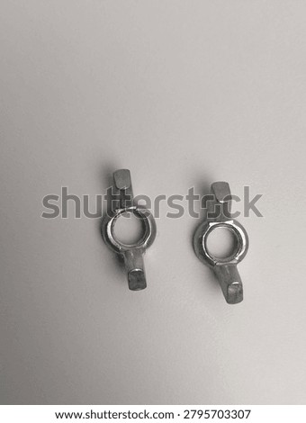 Two wing nuts are located side by side on a gray background