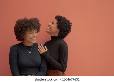 Two woman with curly hair sharing a moment of laughter  - Powered by Shutterstock